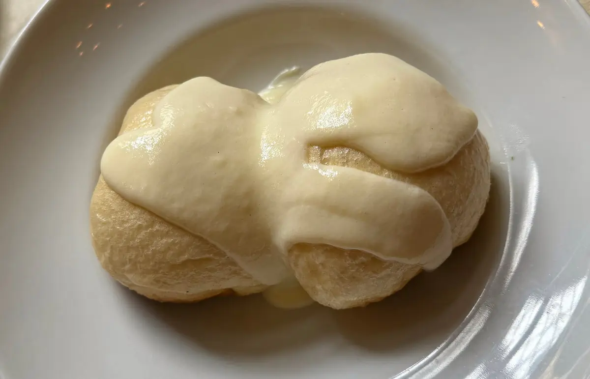 バニラソースをかけたドイツのダンプフヌーデル。白くふわふわした見た目が肉まんの皮に似ている。