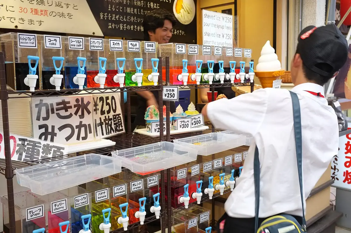 かき氷店に並ぶ色とりどりのシロップのサーバー。イチゴやメロン、ブルーハワイなど30種類の味が名札付きで並ぶ