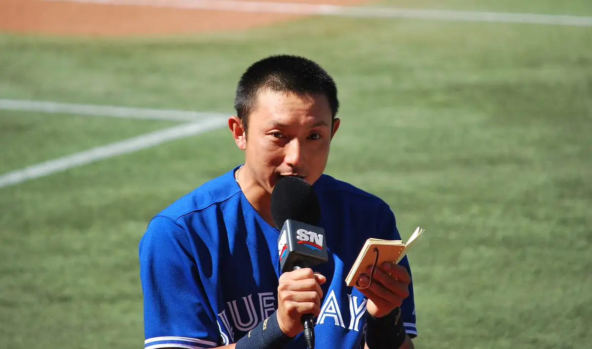 Sportsnetのマイクを持ち、小さなノートを読みながらインタビューに答えるブルージェイズ時代の川崎宗則（2013年5月26日撮影）